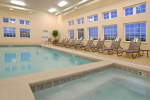 a swimming pool in a hotel room with lounge chairs at Candlewood Suites Polaris, an IHG Hotel in Columbus