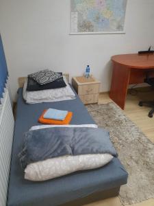 two beds in a room with a table at Pokoje ze wspólną łazienką i kuchnią w centrum Starachowic in Starachowice