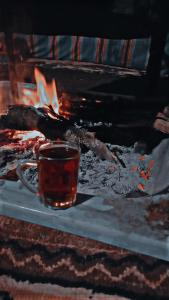 eine Tasse Tee vor dem Kamin in der Unterkunft Areen camp, Wadi Rum in Wadi Rum