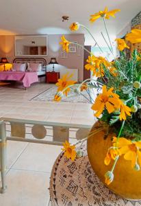 a living room with a vase with yellow flowers in it at Olyna’s Apartment N.S Preveza in Néa Sampsoús