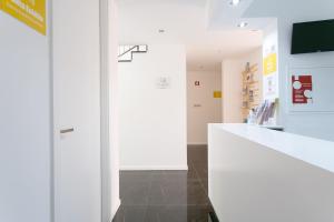 a room with a white counter and a tv at Casa Amarela Guesthouse in Albufeira