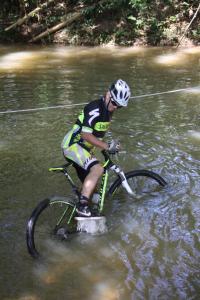 un hombre montando una bicicleta a través de un cuerpo de agua en Finca Summerland ecohotel en Melgar