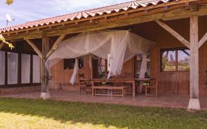 a wooden pavilion with a table and a tent at Longère bressane de la Verne in Cormoz