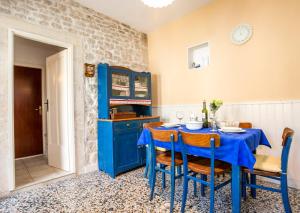 uma sala de jantar azul com uma mesa azul e cadeiras em Visilo Stone House em Pučišća