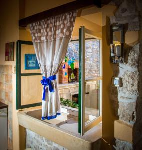 a window with a curtain with a blue bow at Visilo Stone House in Pučišća