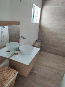 a bathroom with two sinks and a mirror at Elia Small Paradise in Kos Town