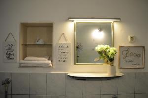 a bathroom with a mirror and a sink and towels at Visilo Stone House in Pučišća