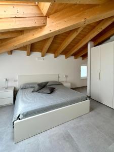 una camera da letto con un grande letto e soffitti in legno di L’Oleandro a Valeggio sul Mincio