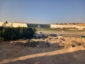 een zandveld met gebouwen op de achtergrond bij Hotel rooms overlooking the new museum in Caïro