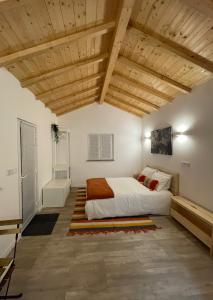 1 dormitorio con cama y techo de madera en Casinha Rubiães, en Paredes de Coura