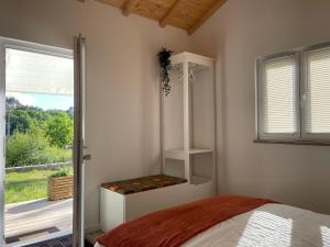 ein Schlafzimmer mit einem Bett neben einem Fenster in der Unterkunft Casinha Rubiães in Paredes de Coura