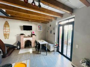 a living room with a table and a fireplace at Maison Capbreton à 4 min des plages in Capbreton