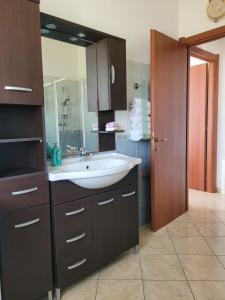 La salle de bains est pourvue d'un lavabo et d'un grand miroir. dans l'établissement Casa Clara, à Bari Sardo