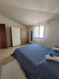 - une chambre avec un lit bleu et une fenêtre dans l'établissement Casa Clara, à Bari Sardo