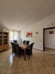 - une salle à manger avec une table et des chaises en bois dans l'établissement Casa Clara, à Bari Sardo