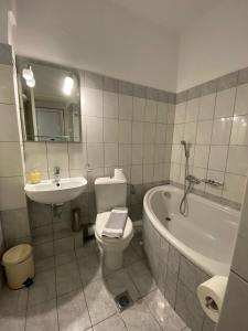 a bathroom with a sink and a toilet and a bath tub at Paradosi Rooms in Igoumenitsa