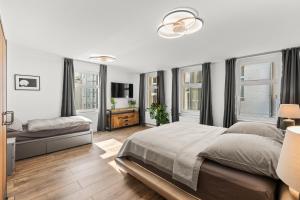 ein weißes Schlafzimmer mit einem großen Bett und Fenstern in der Unterkunft GreatStay - Tieckstr.3 Loft for up to 7 people in Berlin