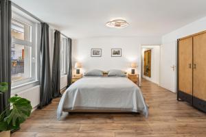 a white bedroom with a bed and a large window at GreatStay - Tieckstr.3 Loft for up to 7 people in Berlin