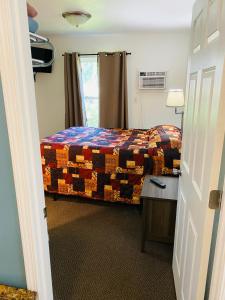 a bedroom with a bed and a table and a window at Scotty's Motel in Munising