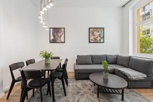 a living room with a couch and a table and chairs at GreatStay - Tieckstr.3 Loft for up to 7 people in Berlin