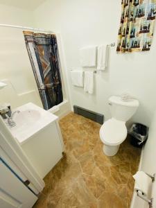 biała łazienka z toaletą i umywalką w obiekcie Scotty's Motel w mieście Munising