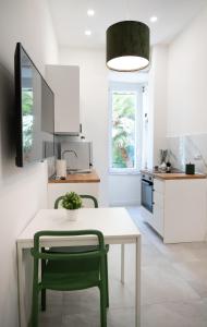 uma cozinha com uma mesa e uma cadeira verde em Green Spera Apartment em Nápoles