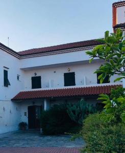 un edificio blanco con ventanas negras y techo rojo en Pietra Ligure - Essential with Swimming Pool, en Pietra Ligure