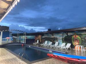 einen Pool auf einem Kreuzfahrtschiff mit Stühlen und Wandmalereien in der Unterkunft Hotel La Villa Morena in Oiapoque