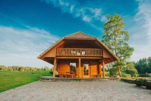 a log cabin with a porch and a deck at Brīvdienu māja ar pirti "Strautkalni" in Ieriķi