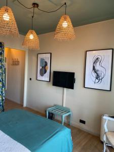 a bedroom with a bed and a tv and lights at H&ocirc;tel Les Aliz&eacute;s in Cavalaire-sur-Mer