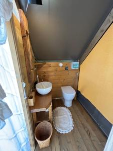 a small bathroom with a toilet and a sink at GLAMPING SUITE IL GRILLO in Lamporecchio +14 photos