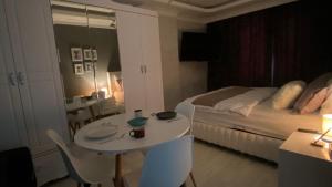 ArnavutköyにあるTC homesのベッド、テーブル、ベッドが備わるホテルルームです。