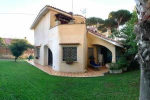 a house with a chair in a yard at Accogliente Villa immersa nel verde in Lido dei Pini