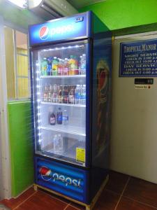an open refrigerator with drinks inside of it at Tropical Manor Inn - Kingston in Kingston