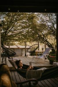 a woman laying in a hammock on a patio at Na miły Bug Guesthouse by Bug river 