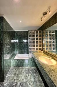 y baño con bañera y lavamanos. en Agradable casa con jacuzzi climatizado exterior en pleno Urdaibai, en Busturia