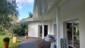 une terrasse couverte d'une maison blanche avec une terrasse. dans l'établissement Agréable Maison sur le Bassin d'Arcachon, à Andernos-les-Bains