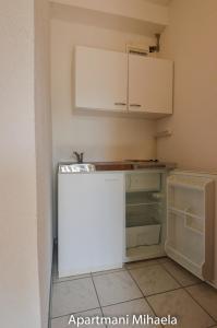 Kruševo的住宿－Mihaela 4，厨房配有白色橱柜和冰箱。