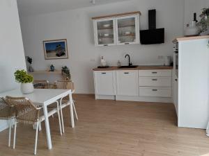 a kitchen with a white table and a white refrigerator at Villa Panama in Pag