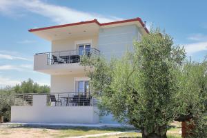 a white building with a tree in front of it at Sandra's luxury stay in Akti Salonikiou