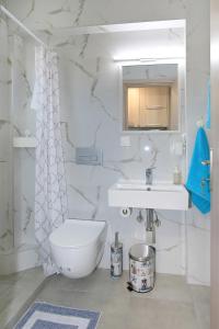 a white bathroom with a sink and a toilet at Sandra's luxury stay in Akti Salonikiou