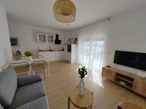 a living room with a couch and a tv and a table at Villa Panama in Pag