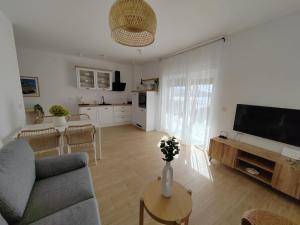 a living room with a couch and a tv and a table at Villa Panama in Pag