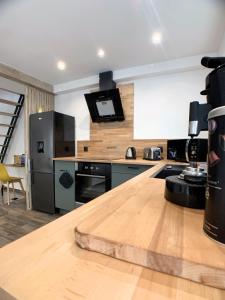 a kitchen with a wooden counter top and a refrigerator at Eco-Appart'hôtel Rouen / SLT in Rouen