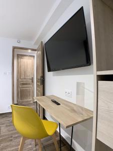 a room with a desk and a television on the wall at Eco-Appart'hôtel Rouen / SLT in Rouen