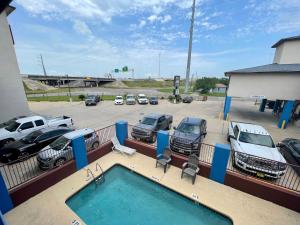 a pool with cars parked in a parking lot at Airport inn & suites in Corpus Christi