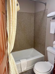 a bathroom with a white tub and a toilet at Airport inn & suites in Corpus Christi