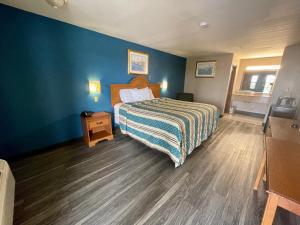a bedroom with a bed and a blue wall at Airport inn & suites in Corpus Christi
