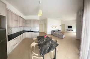 a kitchen and living room with a table and chairs at Dora's apartment in Dhërmi