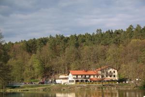una casa al lado de una colina al lado de un lago en Czerwony Domek, en Tleń